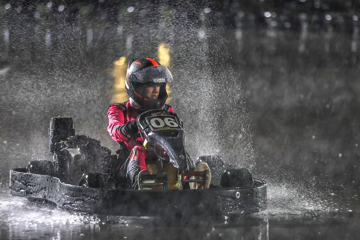 Talita Leal racing a kart in the wet at night